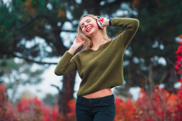 Chica feliz bailando y escuchando la música sobre la naturaleza en otoño —  Fotos de Stock