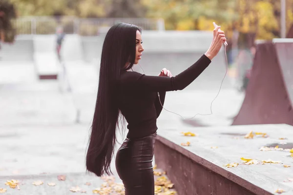 Mujer sexy con el pelo muy largo hace selfie al aire libre — Foto de Stock