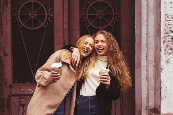 Dos mujeres jóvenes tomando café y divirtiéndose al aire libre —  Fotos de Stock