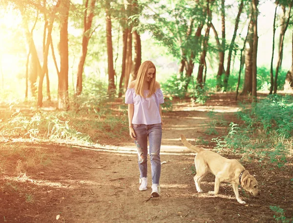Ragazza con un cane golden retriever all'aperto — Foto Stock