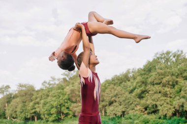 Esnek çocuklar jimnastikçiler akrobatik egzersiz açık yapıyor. Spor, eğitim, fitness, yoga, aktif yaşam tarzı kavramı