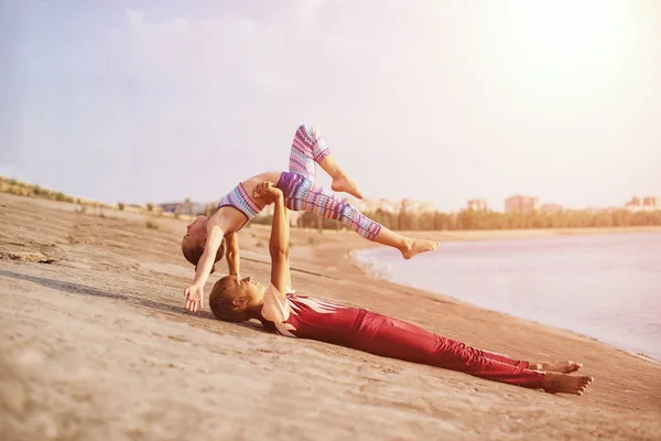 Gimnastas flexibles para niños que hacen ejercicio acrobático al aire libre. Deporte, entrenamiento, fitness, yoga, concepto de estilo de vida activo — Foto de Stock