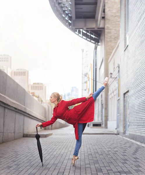 Woman ballerina dance with umbrella in city