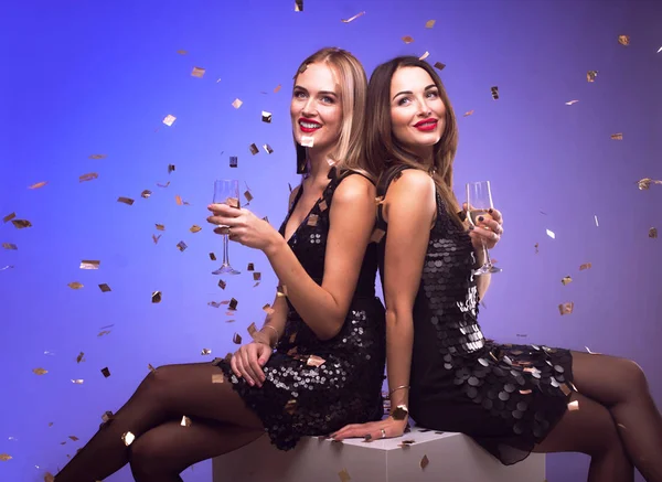 Νέους ελκυστικές γυναίκες γιορτάζουν ένα κόμμα, πίνοντας σαμπάνια και χορό, ενώ κομφετί που υπάγονται — Φωτογραφία Αρχείου