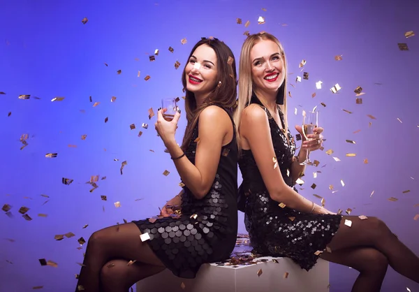 Mladý atraktivní ženy večírku, pití šampaňského a tanec, zatímco konfety pádu — Stock fotografie