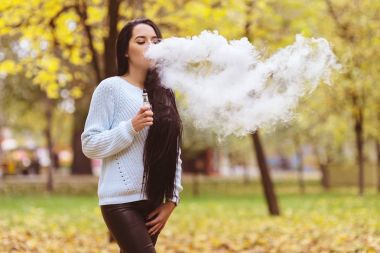 Seksi kadın vaping elektronik nargile sonbaharda açık. Vape hediyeler