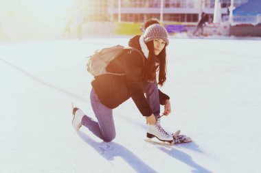 Buz üzerinde oturan buz pateni için yeni bir beyaz paten kız.