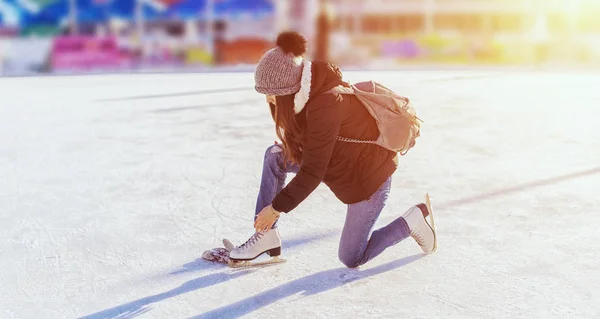 Mulher amarrar atacadores em patins artísticos na pista de gelo, patinação no gelo — Fotografia de Stock