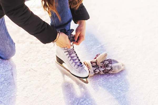 Girl in a new white skates for skating on ice sitting on the ice. — Stock Photo, Image