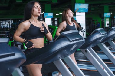 iki kadın spor salonunda çalıştırmak koşu bandı