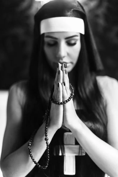 关闭了年轻的修女的肖像。修女祈祷。在黑色背景上的照片. — 图库照片
