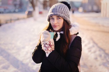 Mutlu genç model güneşli bir günde dışarıda kahve keyfi kış giysileri içinde