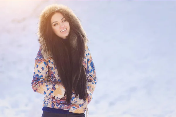 Happy winter moments of joyful young woman with long brunette hair, white winter clothes having fun in snowing time. Expressing positivity, true brightful emotions