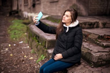 Genç esmer beyaz kadın selfie smartphone ile açık havada park sonbaharda alarak.. Selfie sonbahar. Sonbahar, insanlar, teknoloji, yaşam biçimi kavramı. Genç kadın selfie yapma. Sonbahar selfie portre