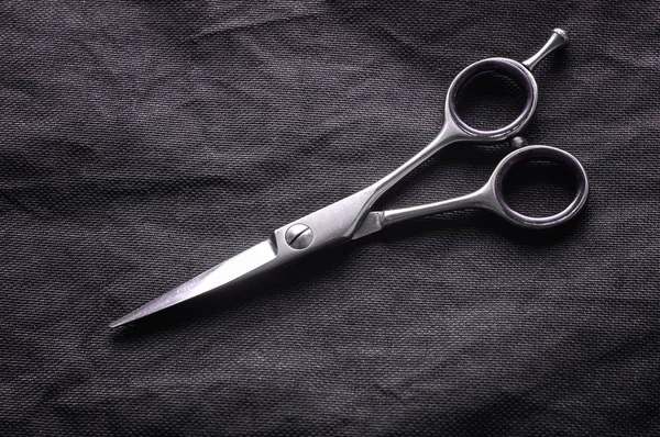 Primer plano de tijera de peluquería sobre fondo negro. Tijeras de barbero cromadas brillantes . — Foto de Stock