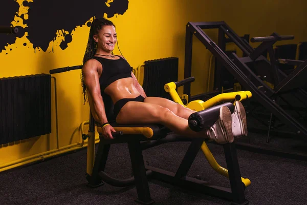 Mujer deportiva joven haciendo ejercicio para las piernas en una máquina de prensa en el gimnasio. Aptitud . — Foto de Stock