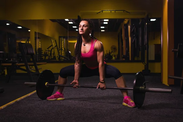 Mujer joven trabajando duro en el gimnasio. Ajuste peso femenino de levantamiento de atletas en el club de salud . — Foto de Stock