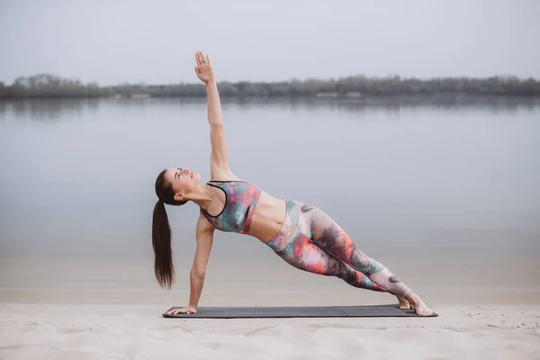 Exercício de treino de ioga Pilates ao ar livre na areia perto do rio — Fotografia de Stock