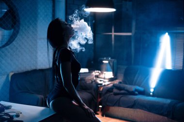Elektronik sigara içen seksi esmer kadın.