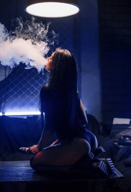 Genç seksi kadın buhar yapıyor. Bir buhar bulutu. Vape.