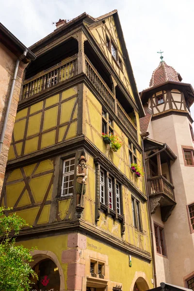 Starý roubený dům a budova s velkou věží v krásné středověké městečko Colmar ve Francii. — Stock fotografie