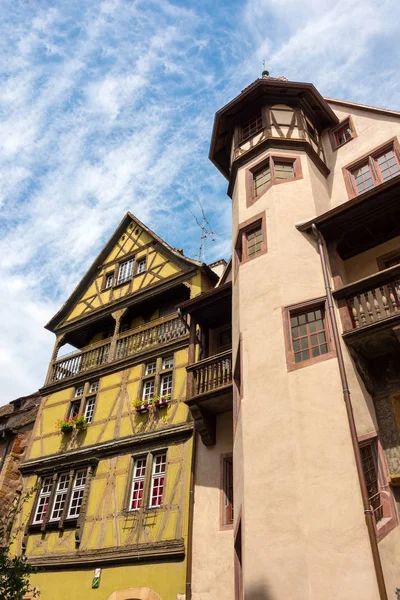 Altes Fachwerkhaus und ein Gebäude mit großem Turm in der schönen mittelalterlichen Stadt Colmar in Frankreich. — Stockfoto