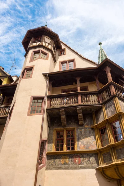 Velha casa de meia-madeira e um edifício com grande torre na bela cidade medieval de Colmar, na França . — Fotografia de Stock