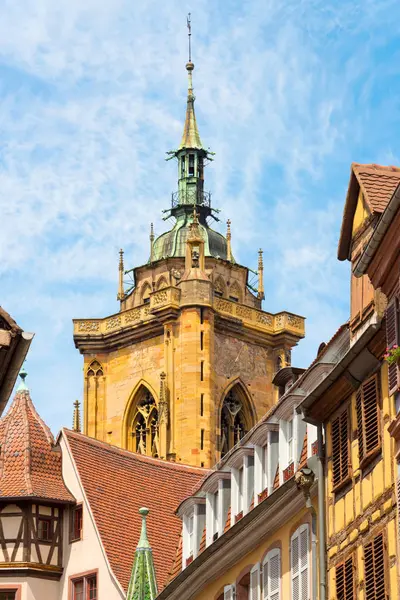 Visa ”St. Martin-kyrkan” och gamla korsvirkeshus hus med färgglada fönsterluckor i den vackra gamla franska staden Colmar i regionen Alsace. — Stockfoto