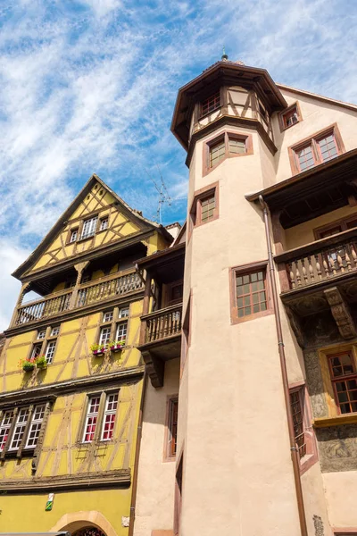 Altes Fachwerkhaus und ein Gebäude mit großem Turm in der schönen mittelalterlichen Stadt Colmar in Frankreich. — Stockfoto