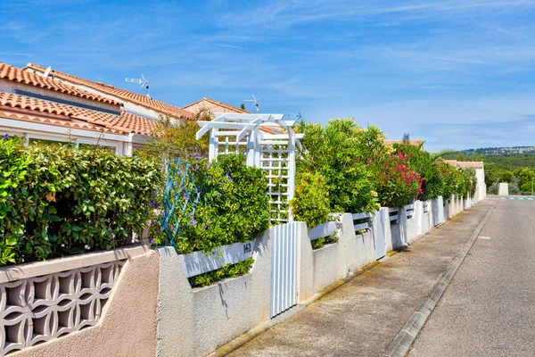 Road and walkway in the holiday resort of Les Ayguades in Gruissan overlooking the beautiful colorful gardens — Stock Photo, Image