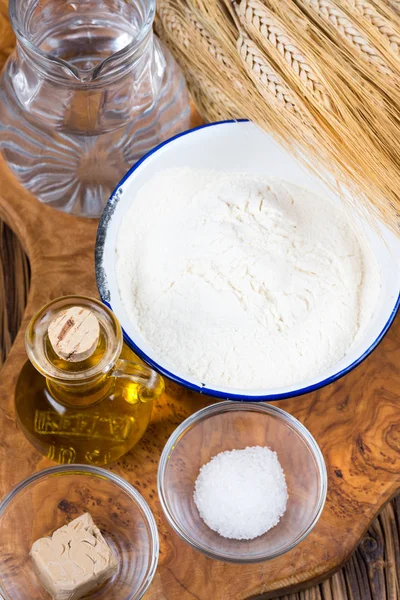 Fresh ingredients for a pizza dough on a wooden board made of olive wood — Stock Photo, Image