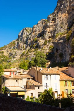 Görünümü küçük dağ köyü Moustiers-Sainte-Marie bir kaya yüzüne önünde eski evler