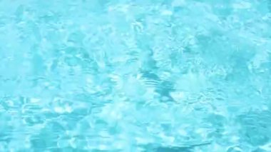 Sparkling and crystal clear water in a pool in sunshine and reflections on the water surface