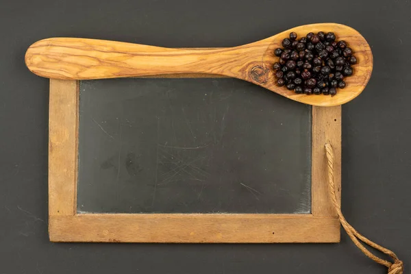 Una Cuchara Cocina Madera Olivo Llena Bayas Enebro Sobre Una — Foto de Stock