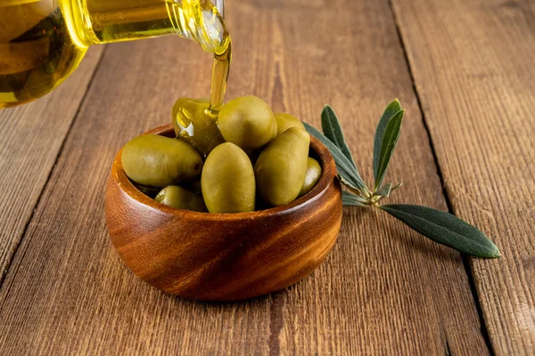 Olive Oil Poured Small Bottle Green Olives Wooden Bowl Taken — Stock Photo, Image