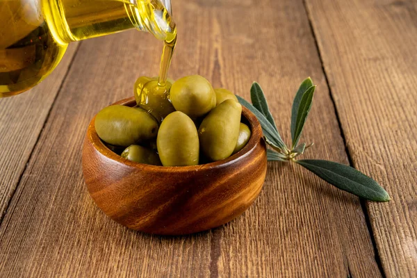 Olive Oil Poured Small Bottle Green Olives Wooden Bowl Taken — Stock Photo, Image