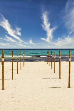 Akdeniz adası Mallorca 'daki Sa Coma' da mevsimin başında şemsiyelerin yerleştirildiği plajda ahşap kutuplar vardır.