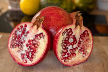 Bir buçuk nar meyvesinin tamamını evcil bir mutfaktaki ahşap kesme tahtasına koy.