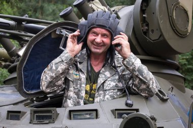 Tank driver in a combat vehicle during training exercises at the range of fire at the Kiev tank repair factory in Kiev, Ukraine clipart