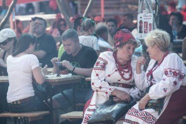 Ulusal kostümleri kadınlar Poltava bölgesinde Velyki Sorochyntsi köyünde geleneksel Ukrayna fuarında bir sokak kafede konuşan, Ukrayna. 23 Ağustos 2015.
