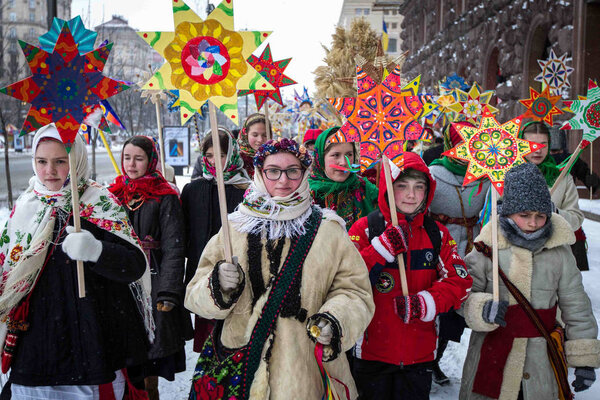 KIEV, UKRAINE - January 7, 2017: People in folk costumes hold symbols of the star of Bethlehem as they celebrate Orthodox Christmas Day in central Kiev, Ukraine.