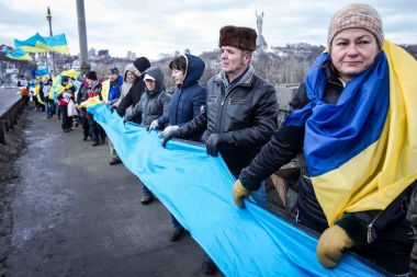 Kiev, Ukrayna - 22 Ocak 2017: Kişi ülke bayrakları bir köprüde bir insan zinciri Dnieper Nehri Kiev, Ukrayna birlik günü kutlamaları sırasında şekillendirme sırasında taşıma.