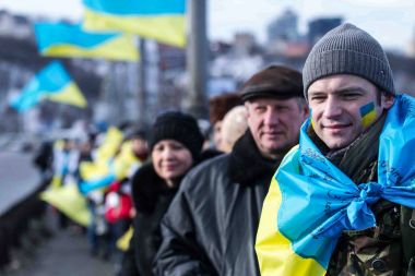 Kiev, Ukrayna - 22 Ocak 2017: Kişi ülke bayrakları bir köprüde bir insan zinciri Dnieper Nehri Kiev, Ukrayna birlik günü kutlamaları sırasında şekillendirme sırasında taşıma.