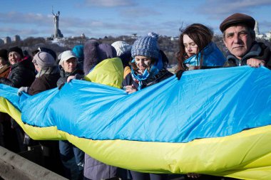 Kiev, Ukrayna - 22 Ocak 2017: Kişi ülke bayrakları bir köprüde bir insan zinciri Dnieper Nehri Kiev, Ukrayna birlik günü kutlamaları sırasında şekillendirme sırasında taşıma.