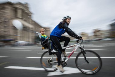 Bir kadın bir çocuk ile Merkezi Kiev, Ukrayna içinde bisiklet geçit töreni sırasında bir bisiklet sürmek