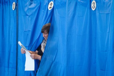 An old woman votes at a polling station during local elections in Chernihiv, Ukraine clipart