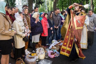 Ukraynalı Ortodoks rahip sprinkles kutsal su müminler Ortodoks Paskalya hizmet Kiev, Ukrayna Volodymysky katedralde dışında arifesinde