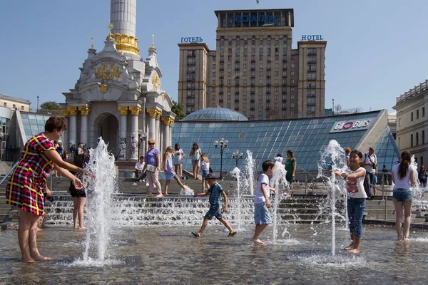 Люди охлаждаются в фонтане в жаркий день на Площади Независимости в Киеве, Украина — стоковое фото