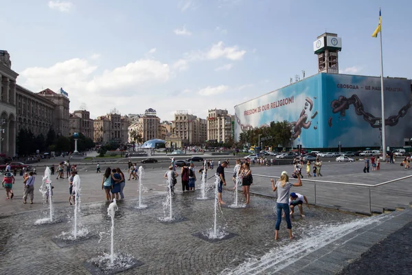 Люди охлаждаются в фонтане в жаркий день на Площади Независимости в Киеве, Украина — стоковое фото