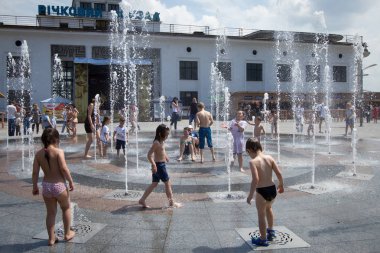 People are cooling in the fountain on a hot day in central Kiev, Ukraine clipart